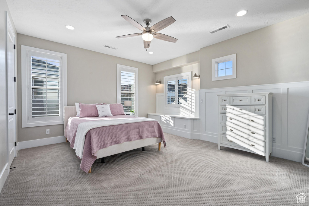 Bedroom with light carpet, ceiling fan, and recessed lighting