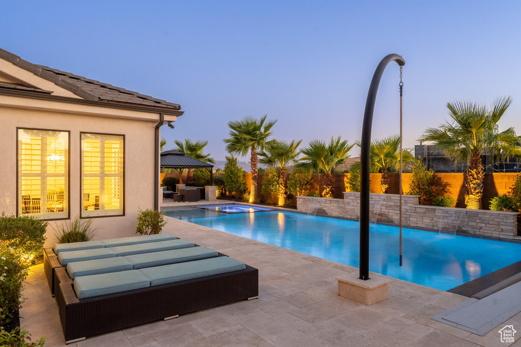 View of pool with outdoor lounge area, a patio area, a fenced backyard, and a gazebo