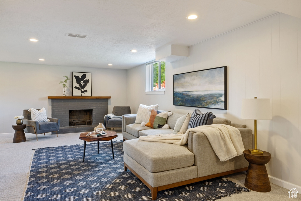 Carpeted living room with recessed lighting and a fireplace