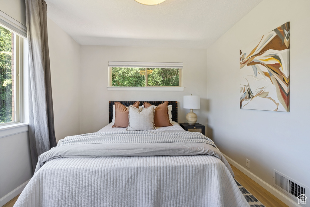 Bedroom featuring multiple windows and wood finished floors