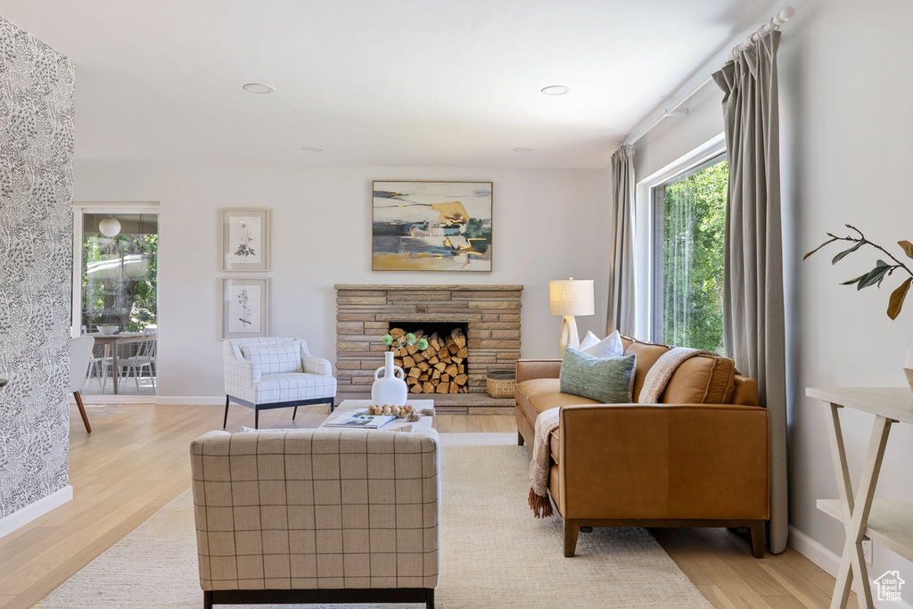 Living area with light wood-type flooring, a stone fireplace, and recessed lighting