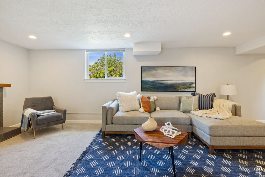 Living room featuring carpet, recessed lighting, and a textured ceiling