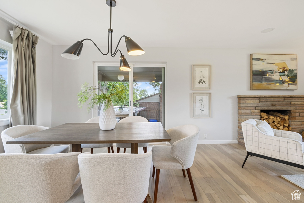 Dining space with light wood-style flooring and a stone fireplace
