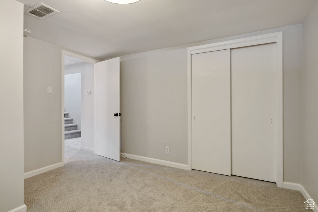 Unfurnished bedroom with carpet and a closet