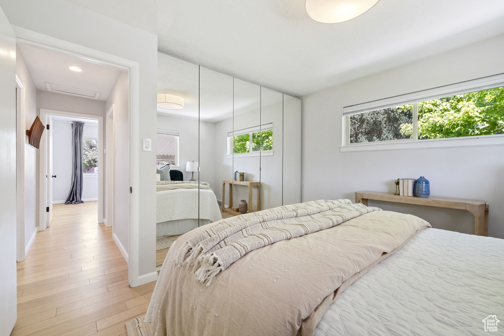 Bedroom featuring attic access, light wood-type flooring, recessed lighting, and a closet