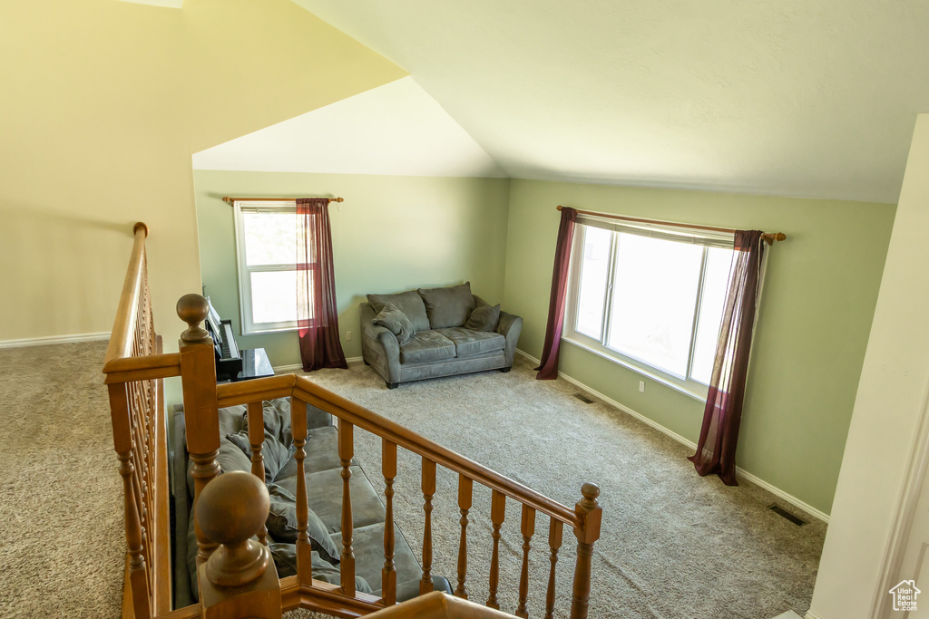 Stairway with carpet and vaulted ceiling