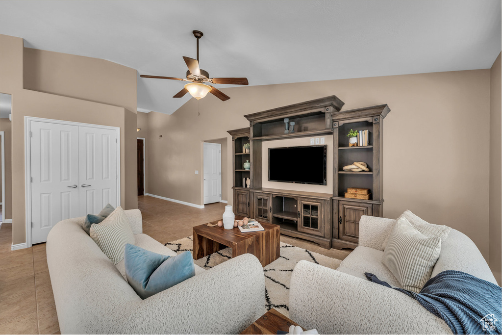 Living room featuring light tile patterned floors, a ceiling fan, and lofted ceiling
