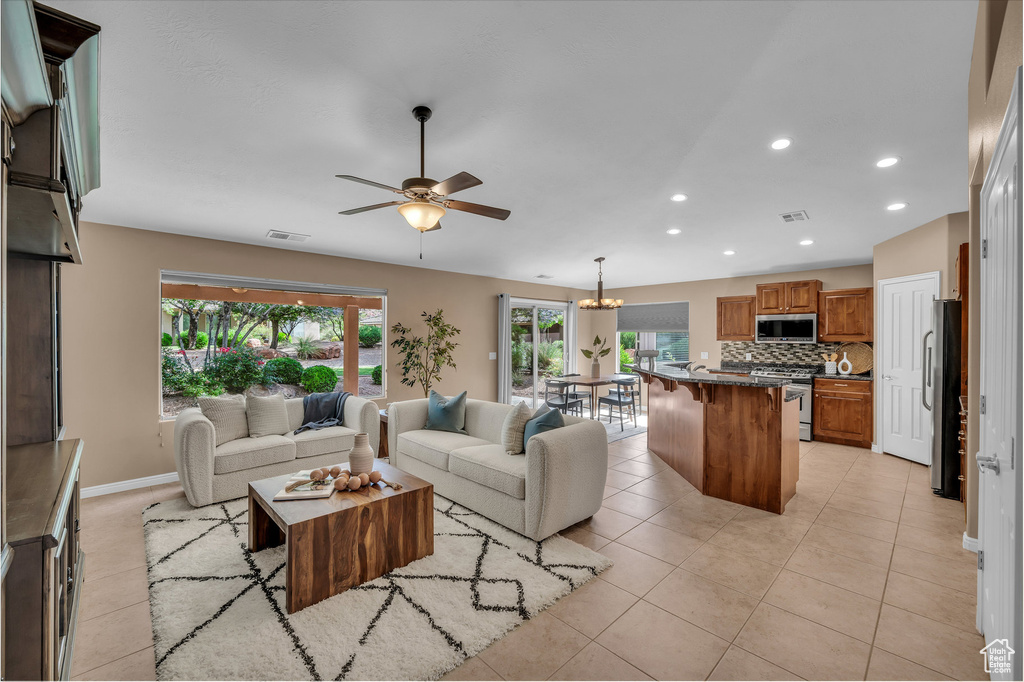 Living area featuring ceiling fan, light tile patterned floors, and recessed lighting