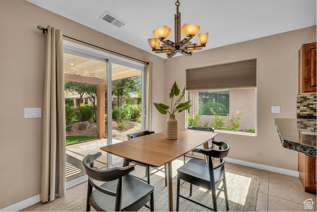 Dining space featuring plenty of natural light, a chandelier, and light tile patterned flooring