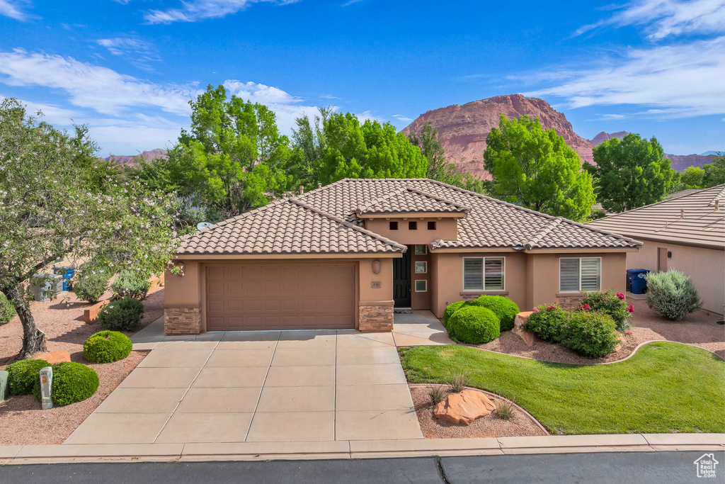 Mediterranean / spanish home featuring stucco siding, driveway, a garage, and a mountain view