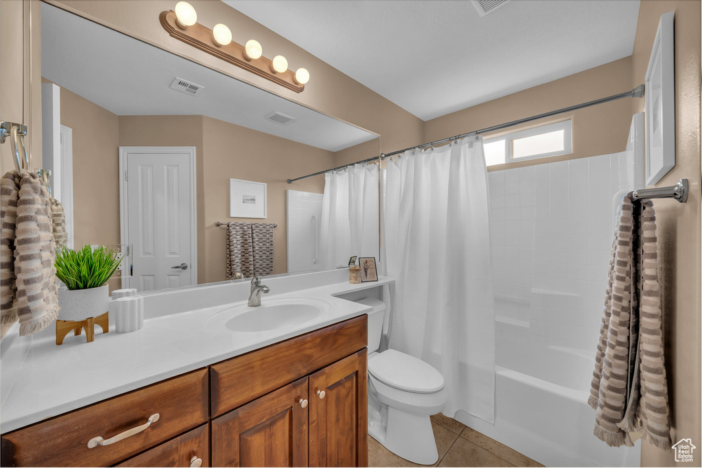 Bathroom featuring tile patterned floors, vanity, and shower / bath combo