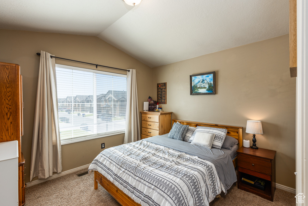Bedroom with carpet, lofted ceiling, and baseboards