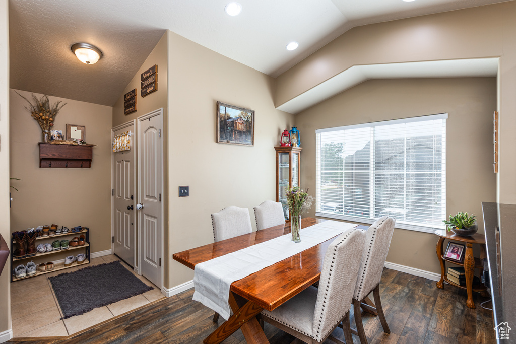 Dining room with lofted ceiling, wood finished floors, and baseboards