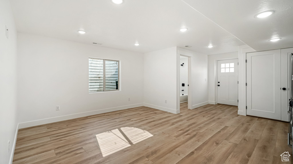 Entryway with light wood finished floors and recessed lighting