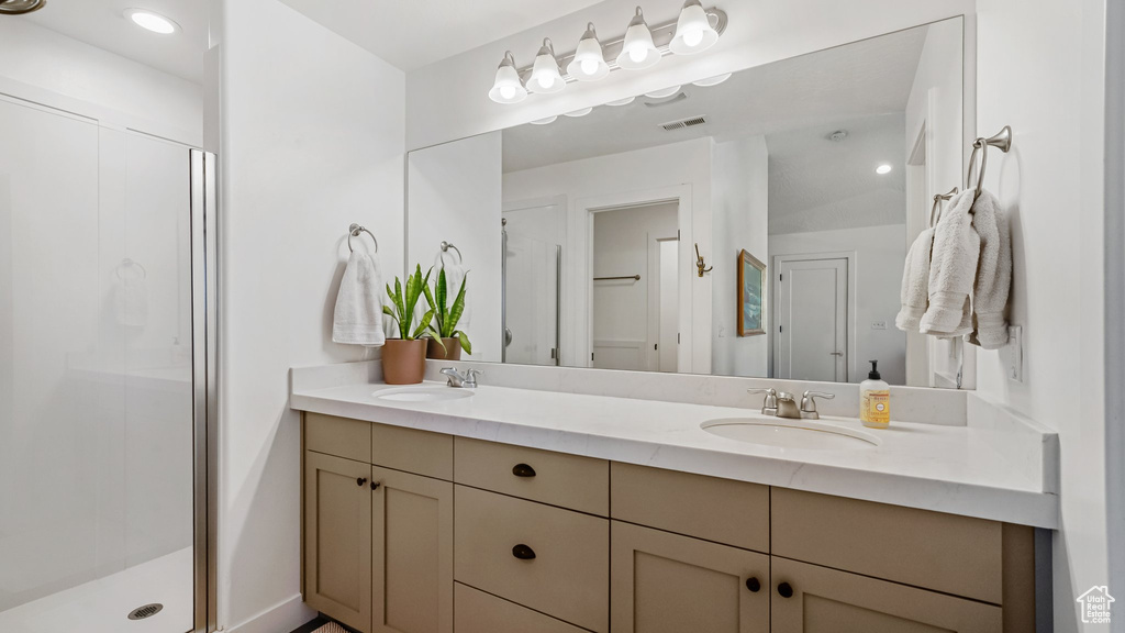 Bathroom featuring double vanity and a stall shower