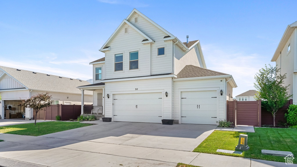 Traditional-style home featuring concrete driveway, roof with shingles, and an attached garage