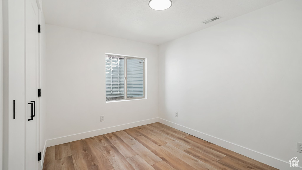 Unfurnished bedroom with light wood finished floors and baseboards