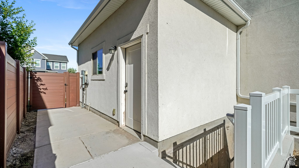 View of side of property featuring a gate and stucco siding
