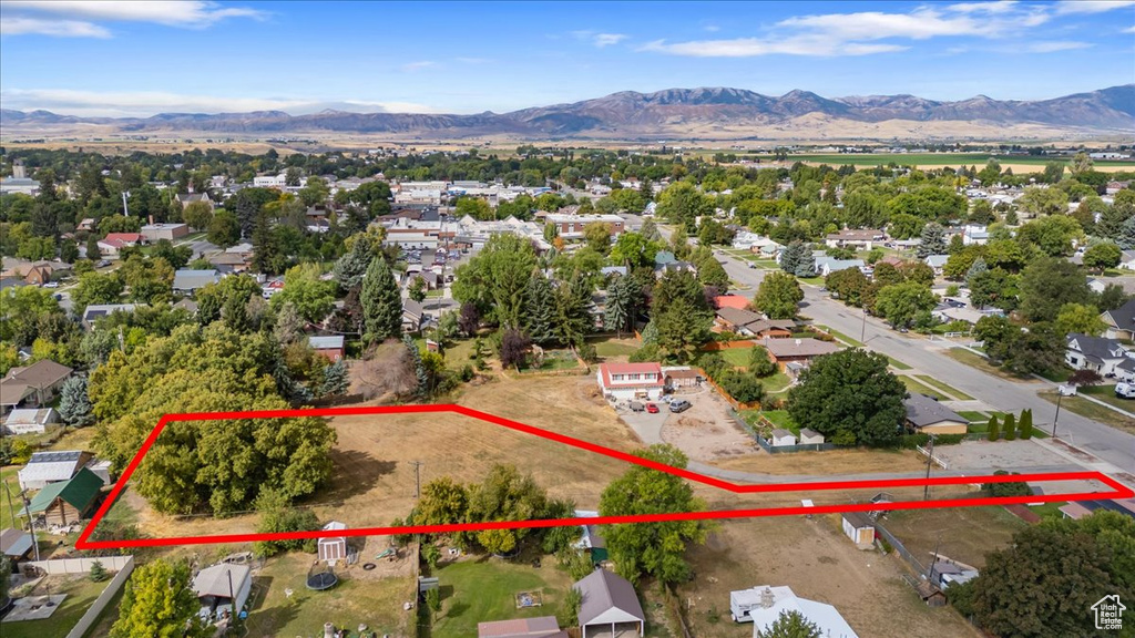 Aerial view of residential area with mountains and property boundaries highlighted
