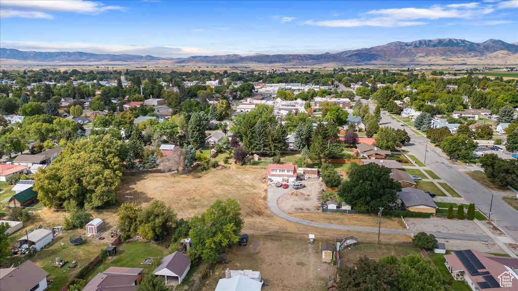 Aerial view of property and surrounding area with a mountain backdrop and nearby suburban area