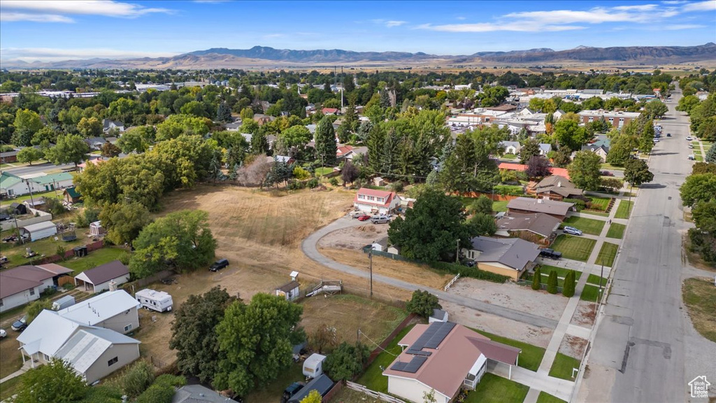 Aerial overview of property's location with a mountainous background and nearby suburban area