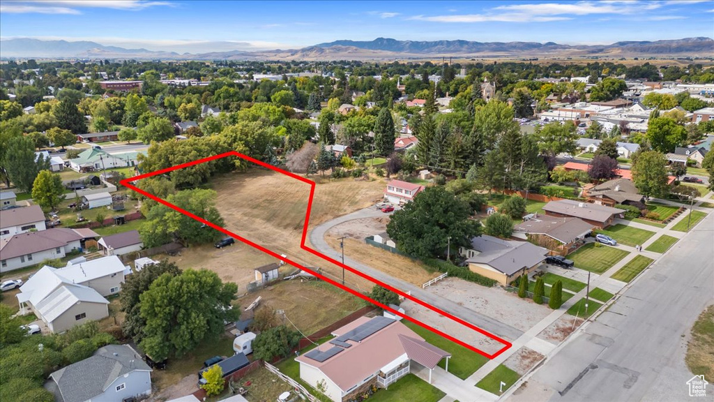 Aerial view of residential area featuring mountains and property boundaries highlighted