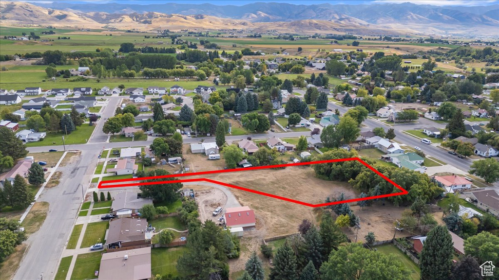 Aerial overview of property's location featuring a mountainous background and property parcel outlined