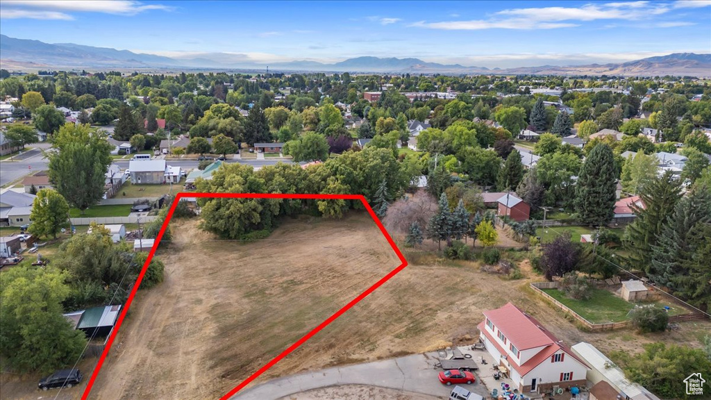 Aerial view of property and surrounding area featuring mountains and property parcel outlined