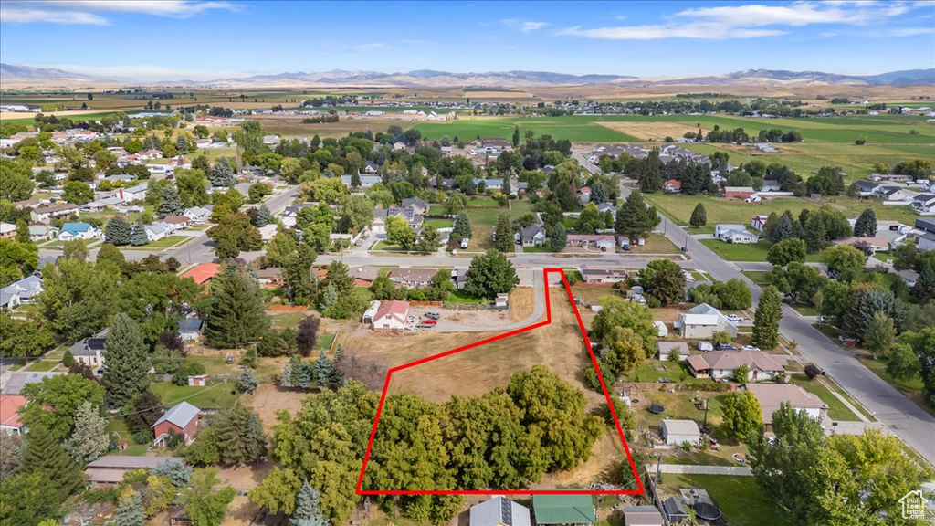 Aerial perspective of suburban area with mountains and property parcel outlined