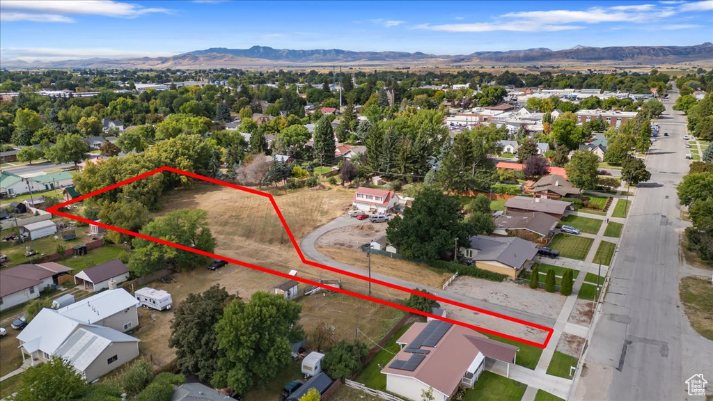 Aerial perspective of suburban area with a mountainous background and property boundaries highlighted