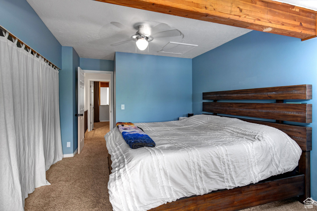 Bedroom with carpet flooring, attic access, and ceiling fan