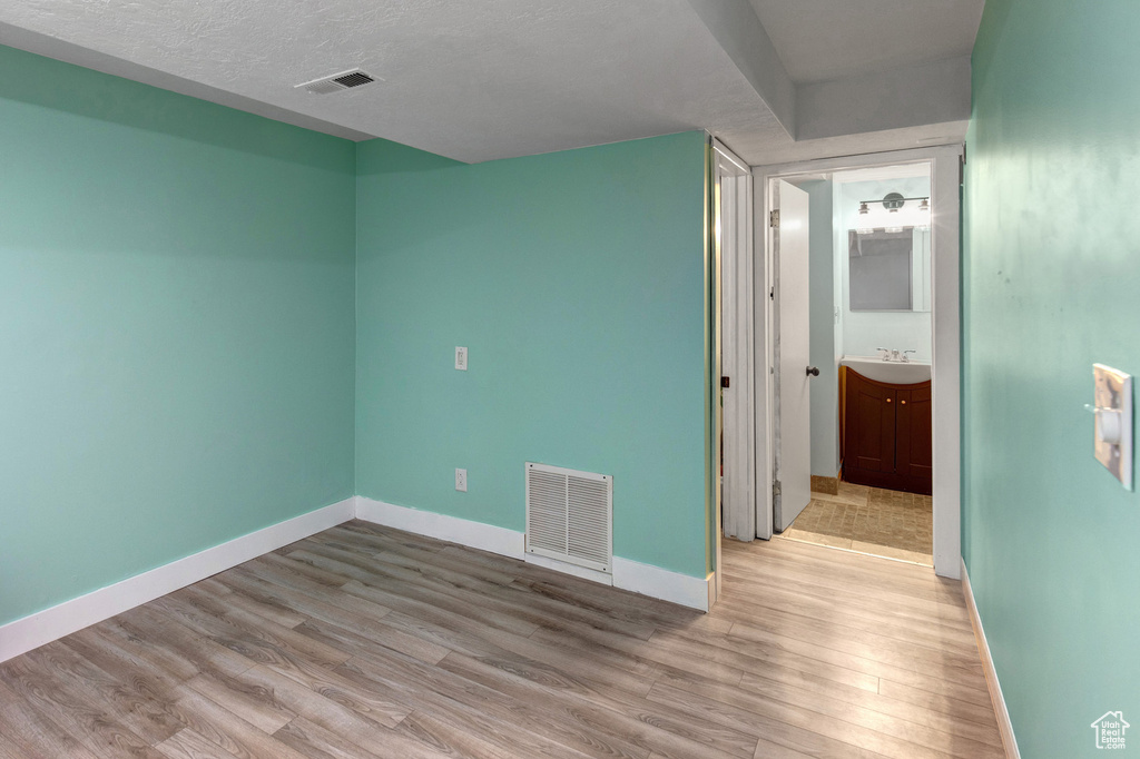 Spare room with light wood-style floors and a textured ceiling