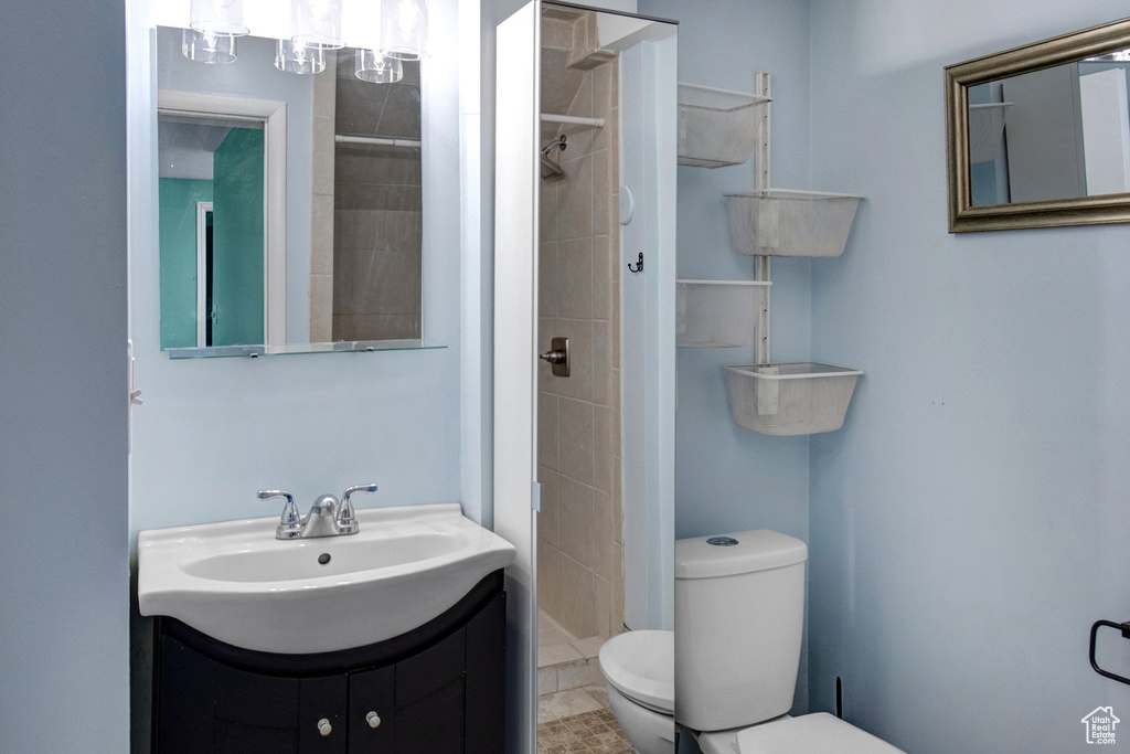 Full bath with tiled shower and vanity