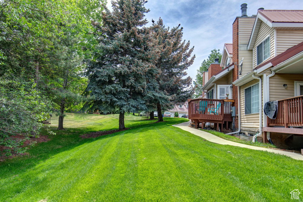 View of grassy yard with a deck