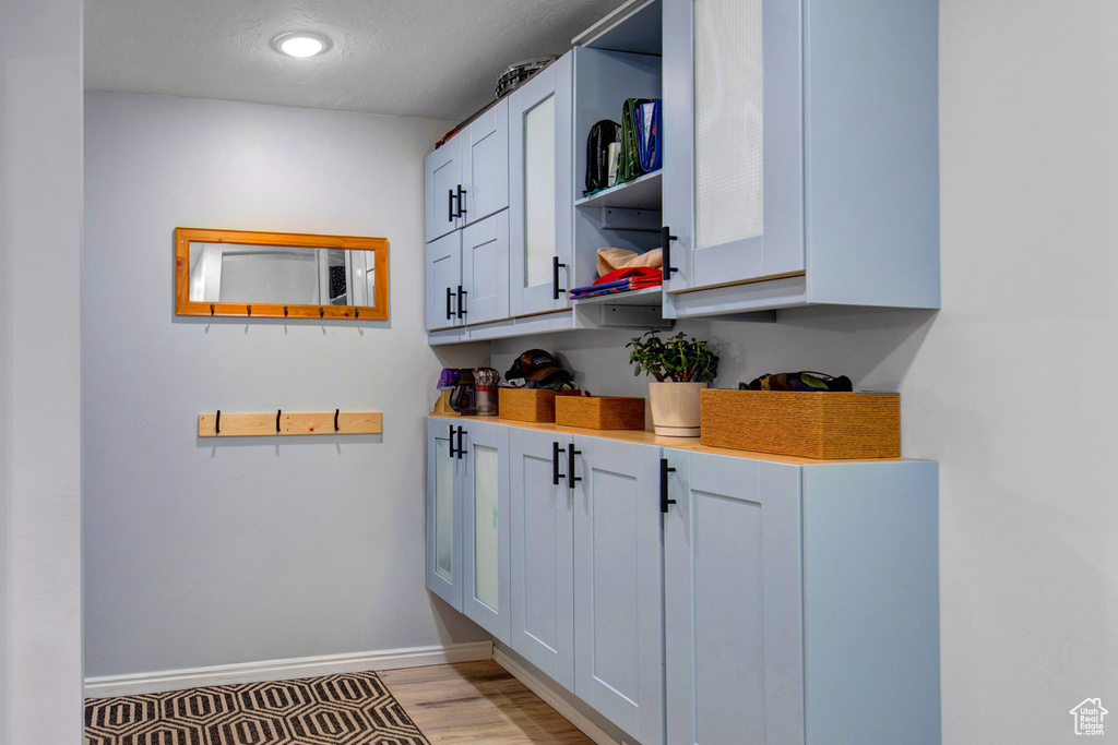 Kitchen with open shelves, light wood-style floors, and light countertops