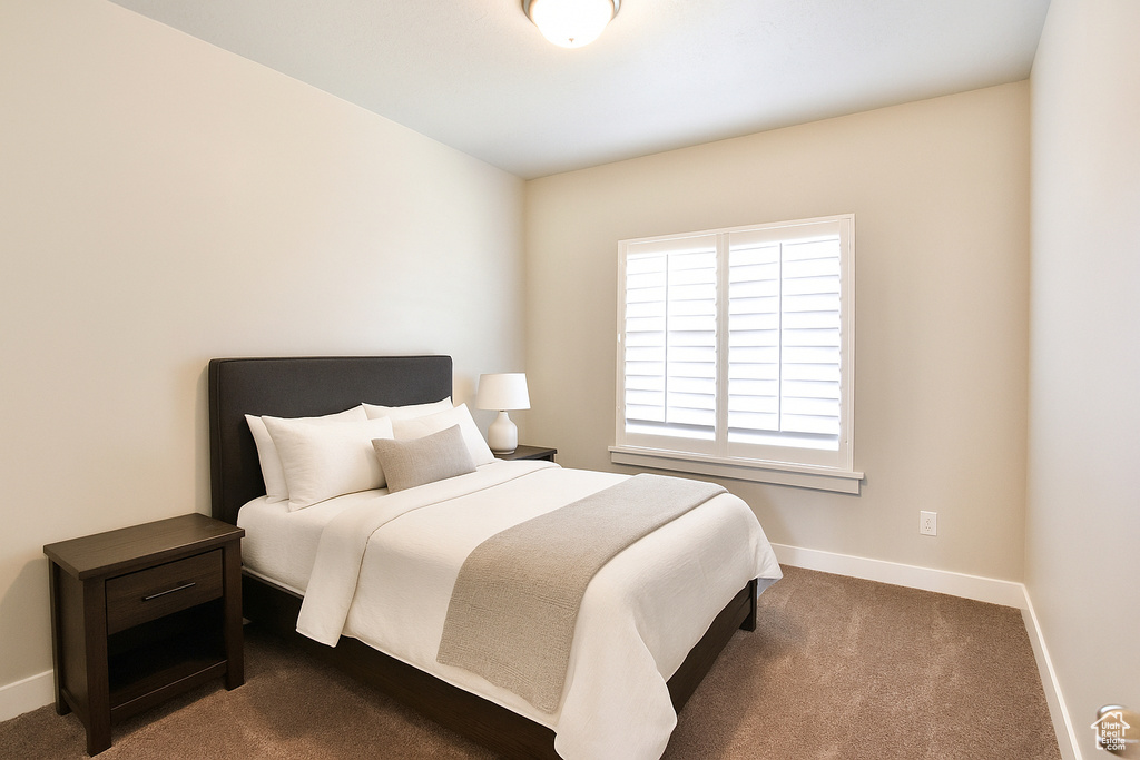 Bedroom with baseboards and dark colored carpet