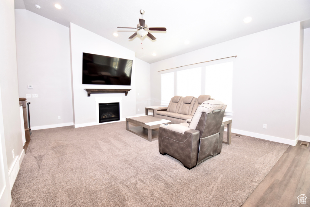 Living area with vaulted ceiling, ceiling fan, a fireplace, baseboards, and recessed lighting