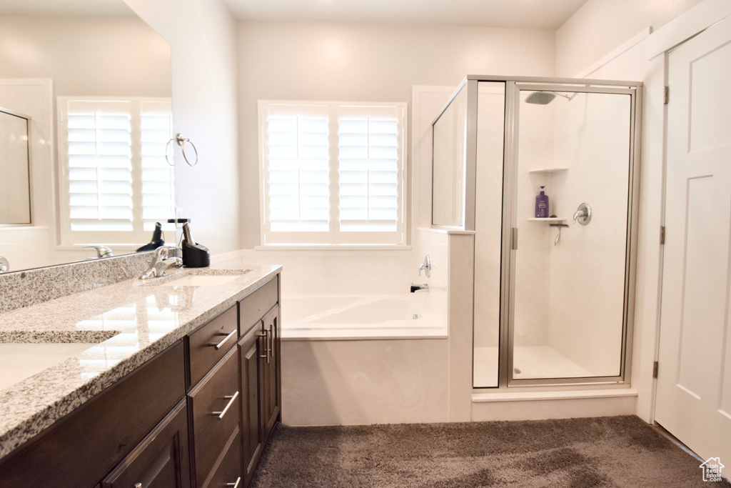 Full bath featuring a stall shower, a garden tub, and double vanity