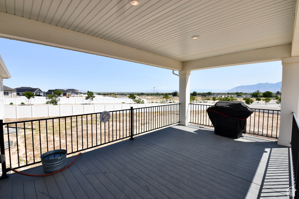 Wooden terrace featuring a mountain view and a grill