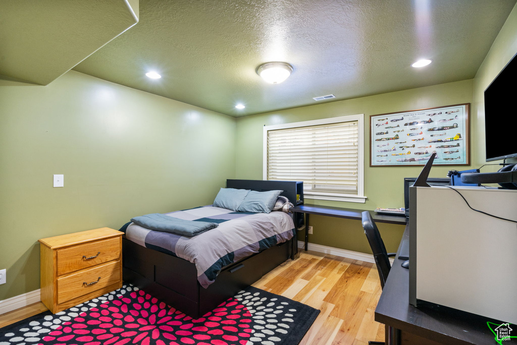 Bedroom with light wood-style flooring, recessed lighting, and a textured ceiling