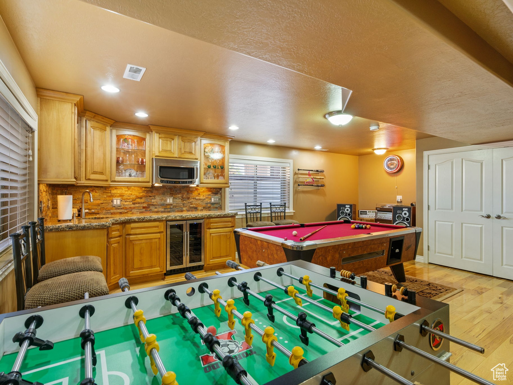 Rec room with beverage cooler, light wood-type flooring, pool table, wet bar, and recessed lighting