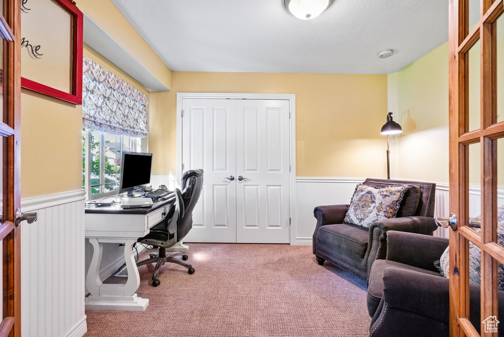 Carpeted home office featuring wainscoting