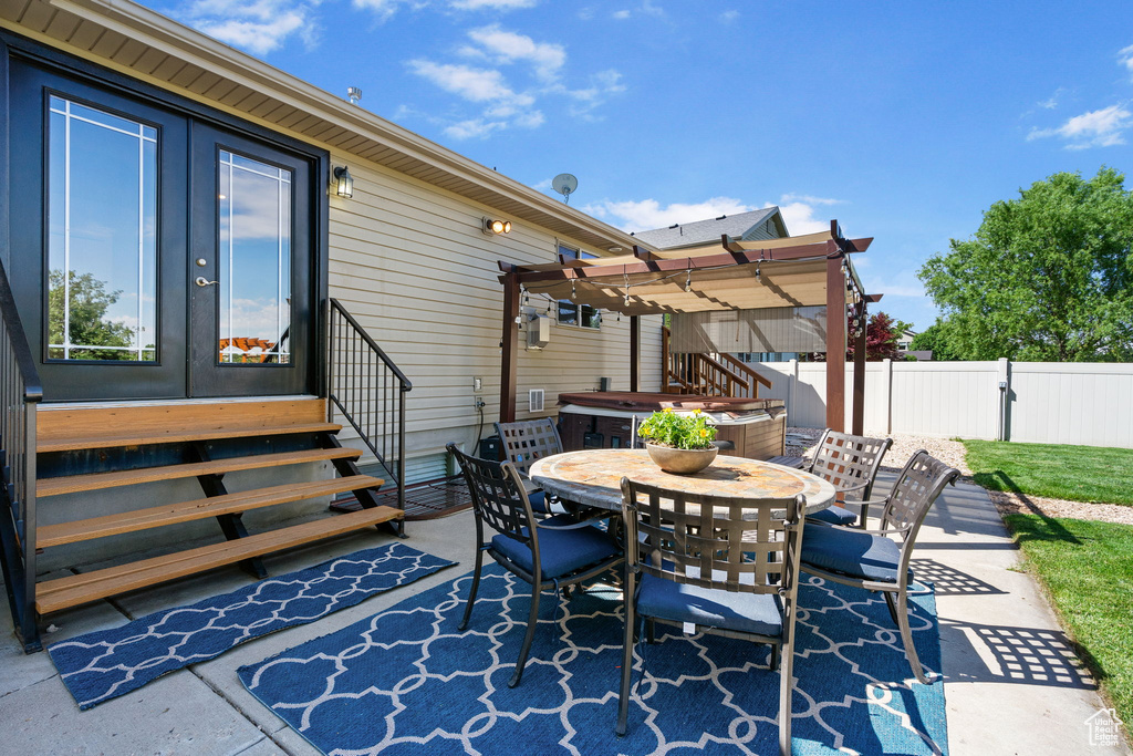 View of patio / terrace featuring outdoor dining space, a hot tub, a pergola, french doors, and entry steps