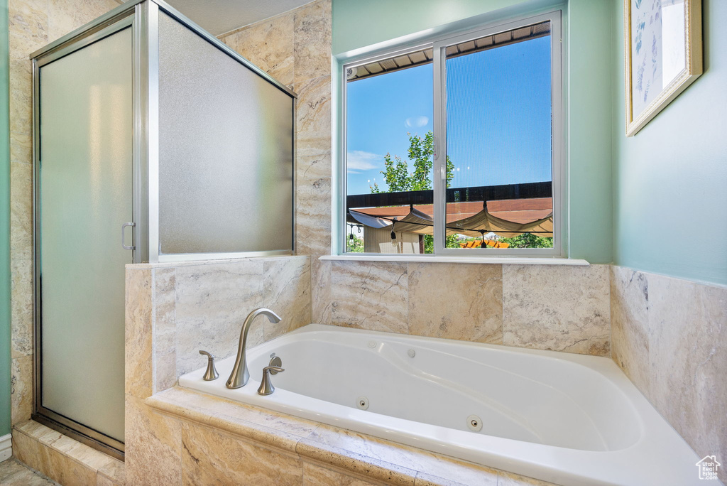 Full bathroom with a shower stall and a jetted tub
