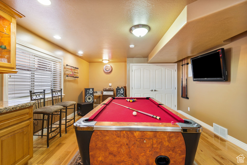 Recreation room with light wood finished floors, billiards, recessed lighting, and a textured ceiling