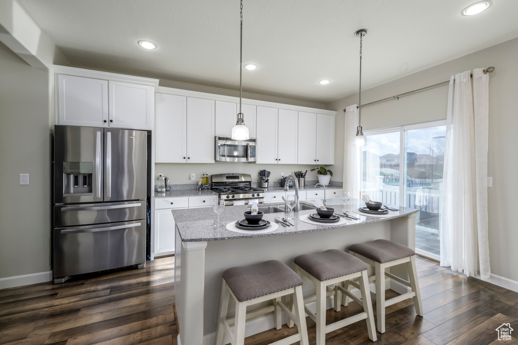 Kitchen featuring stainless steel appliances, white cabinetry, recessed lighting, dark wood finished floors, and a sink