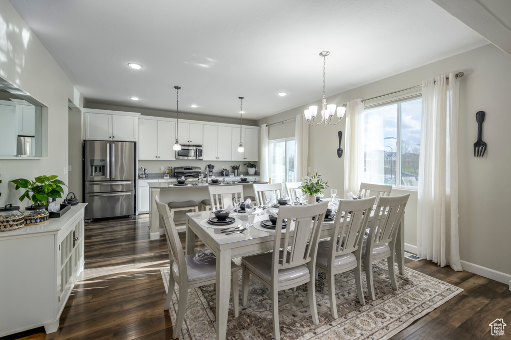 Dining space with recessed lighting, dark wood finished floors, a chandelier, and baseboards
