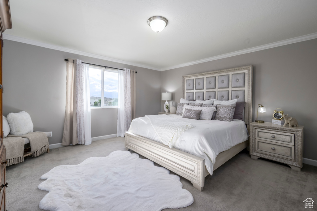 Bedroom with crown molding, light carpet, and baseboards