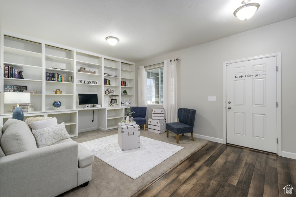 Living room with wood finished floors, baseboards, and a desk