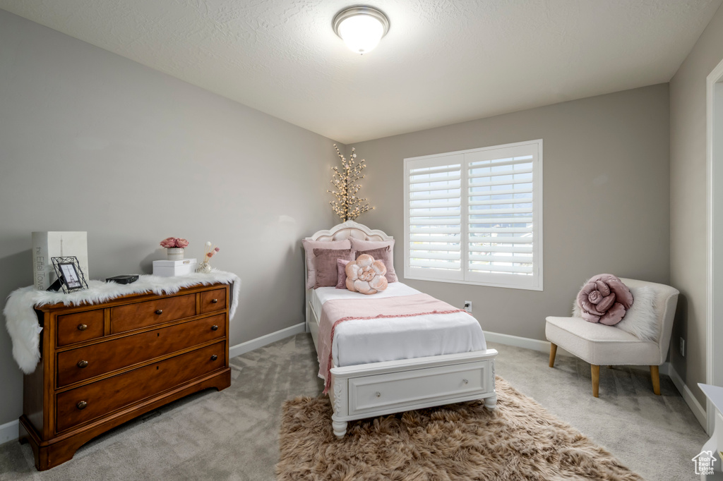 Bedroom featuring light carpet and baseboards